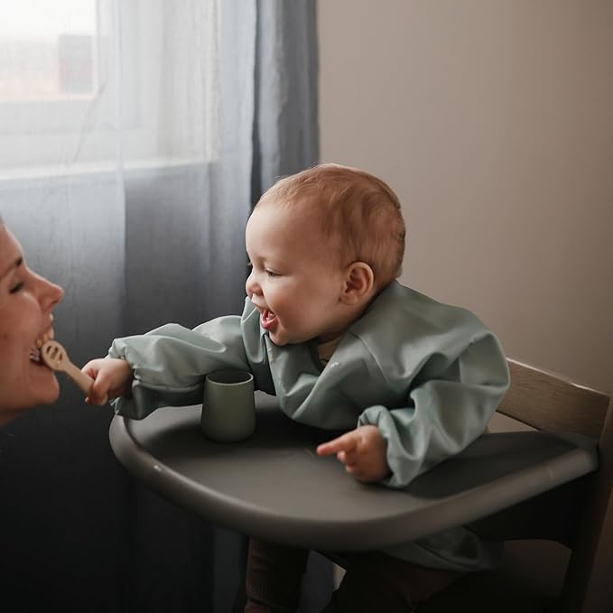 mushie Long Sleeve Baby Bib | Water Resistant Adjustable Fit for Ages 6-24 Months